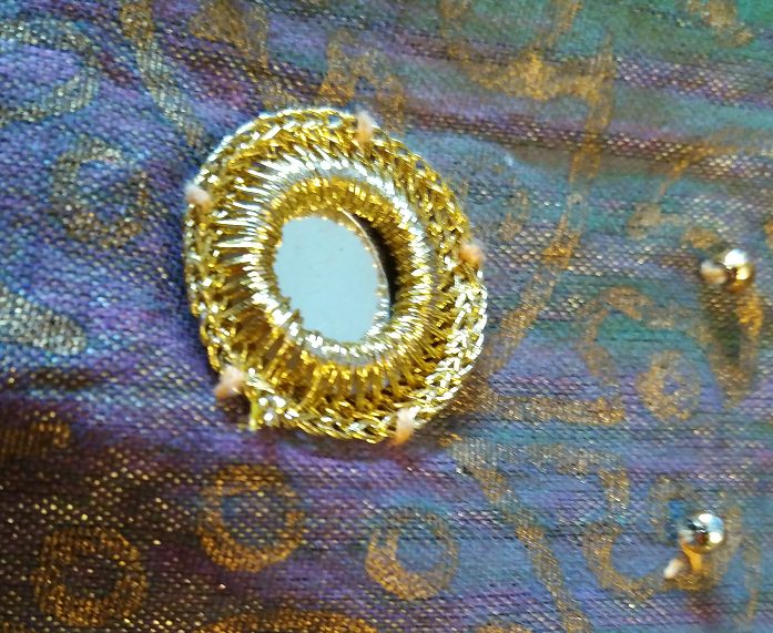 Close-up of shisha (mirror) framed by embroidery stitches
