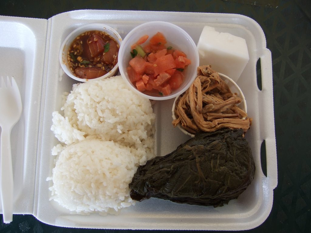 A plate lunch from the Ward Farmer's Market: ahi poke (raw ahi tuna marinated in shoyu soy sauce, similar to ceviche), lomi lomi salmon , kalua pork and pork lau lau (pork slow cooked in taro leaves) - served with two scoops of rice and one block of haupia (a coconut…