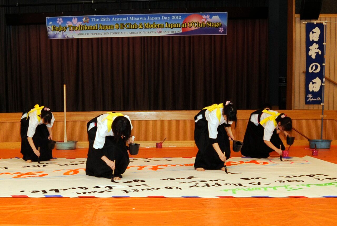 Students from Hachinohe Higashi High School perform a calligraphy dance during the 25th Annual Japan Day at Misawa Air Base, Japan, April 7, 2012. The students performed twice, making a large banner in Japanese and then one in English.