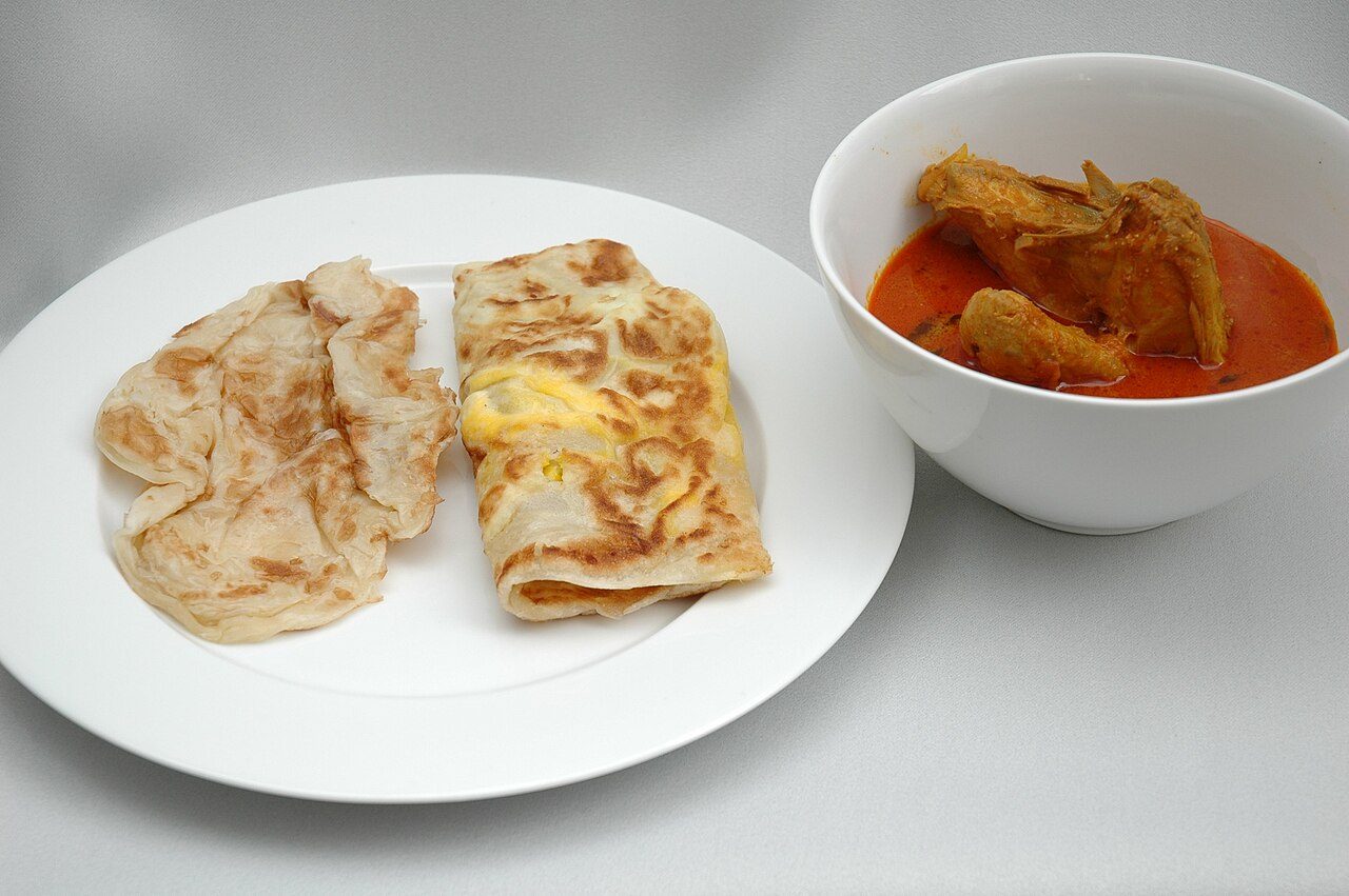 Roti prata (left) and egg prata (center), with a bowl of chicken curry (right) Taken by jpatokal at Contentshare Studios