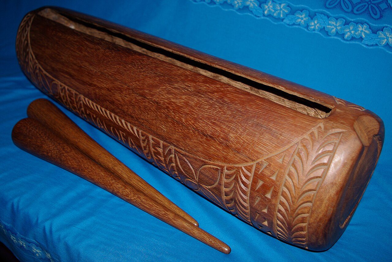Polynesian slit drum and two drum sticks, made in Samoa. This drum is made of Samoan Ironwood, locally called Ifilele.