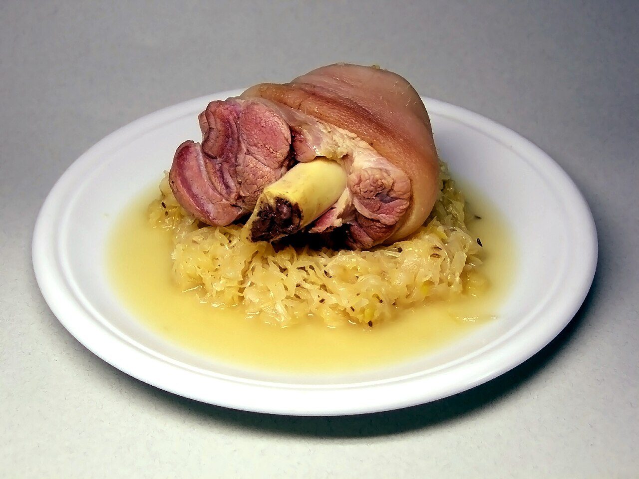 Pickled Eisbein, with Sauerkraut. Eisbein is heavily marbled meat covered with a thick layer of fat.