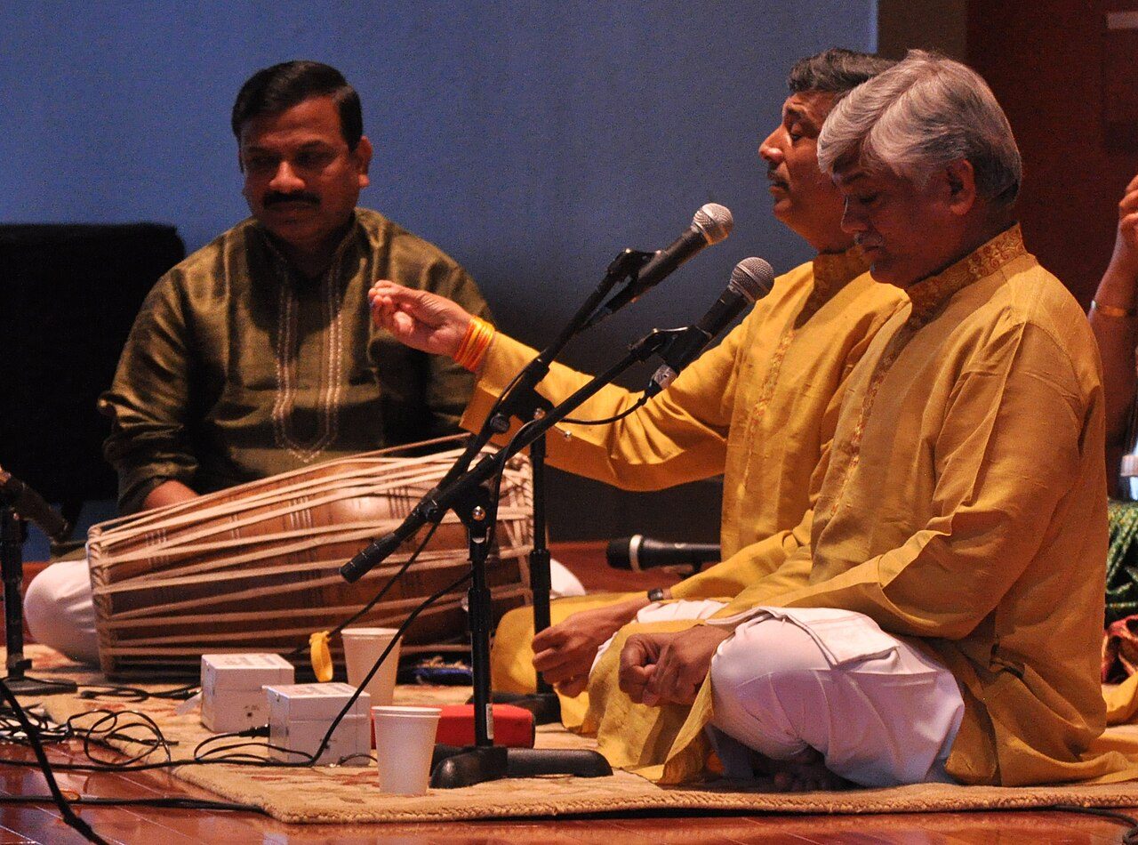 The Gundecha Brothers , performing at the Baha'i Center in Bellevue, Washington, USA. Left to right: Akhilesh Gundecha (pakhawaj), Umakant Gundecha (vocals), Ramakant Gundecha (vocals).