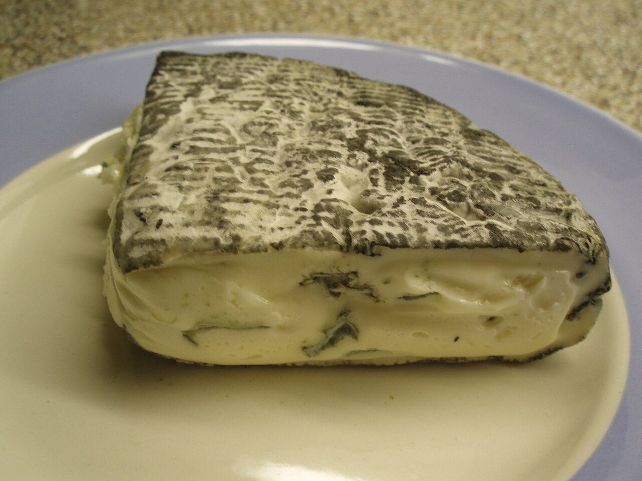 A piece of Rochebaron cheese on a plate in Weetjesman 's kitchen