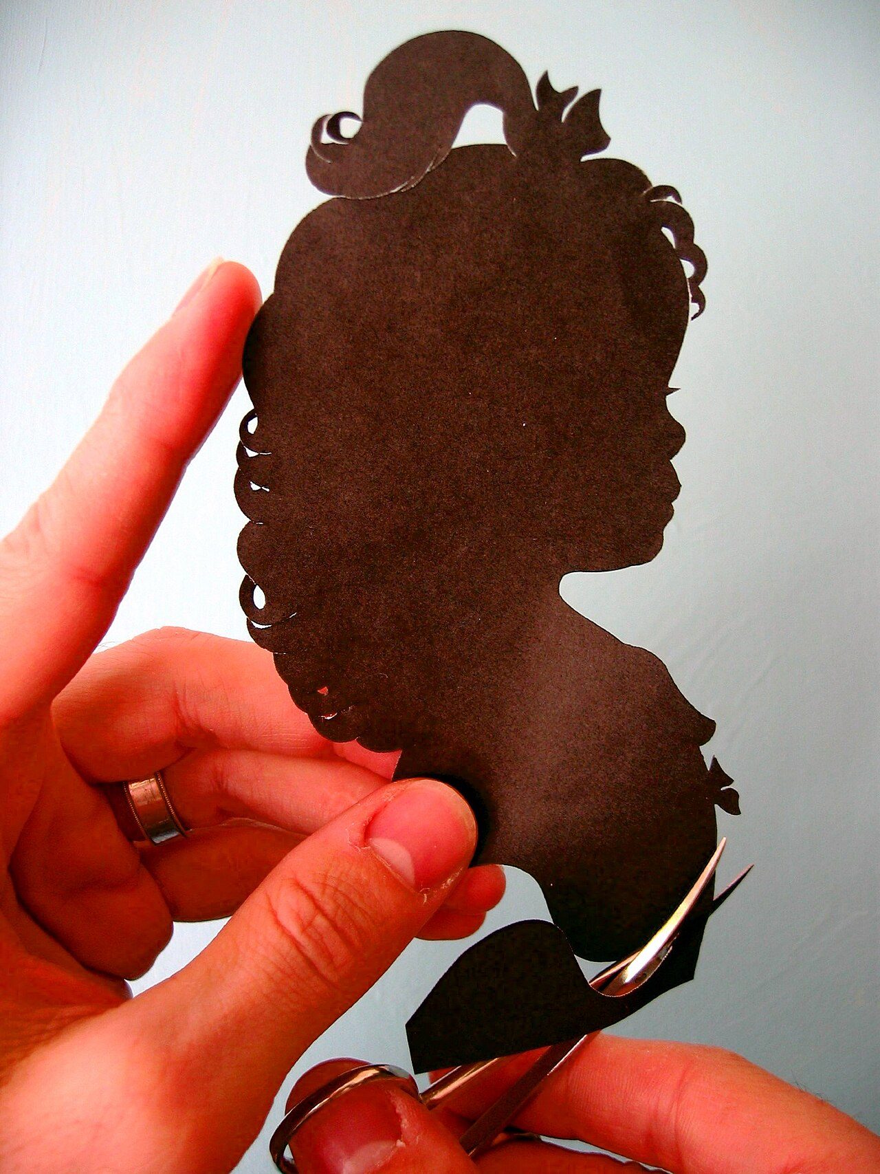Hands cutting silhouette of girl Author Karl Johnson http://www.cutarts.com