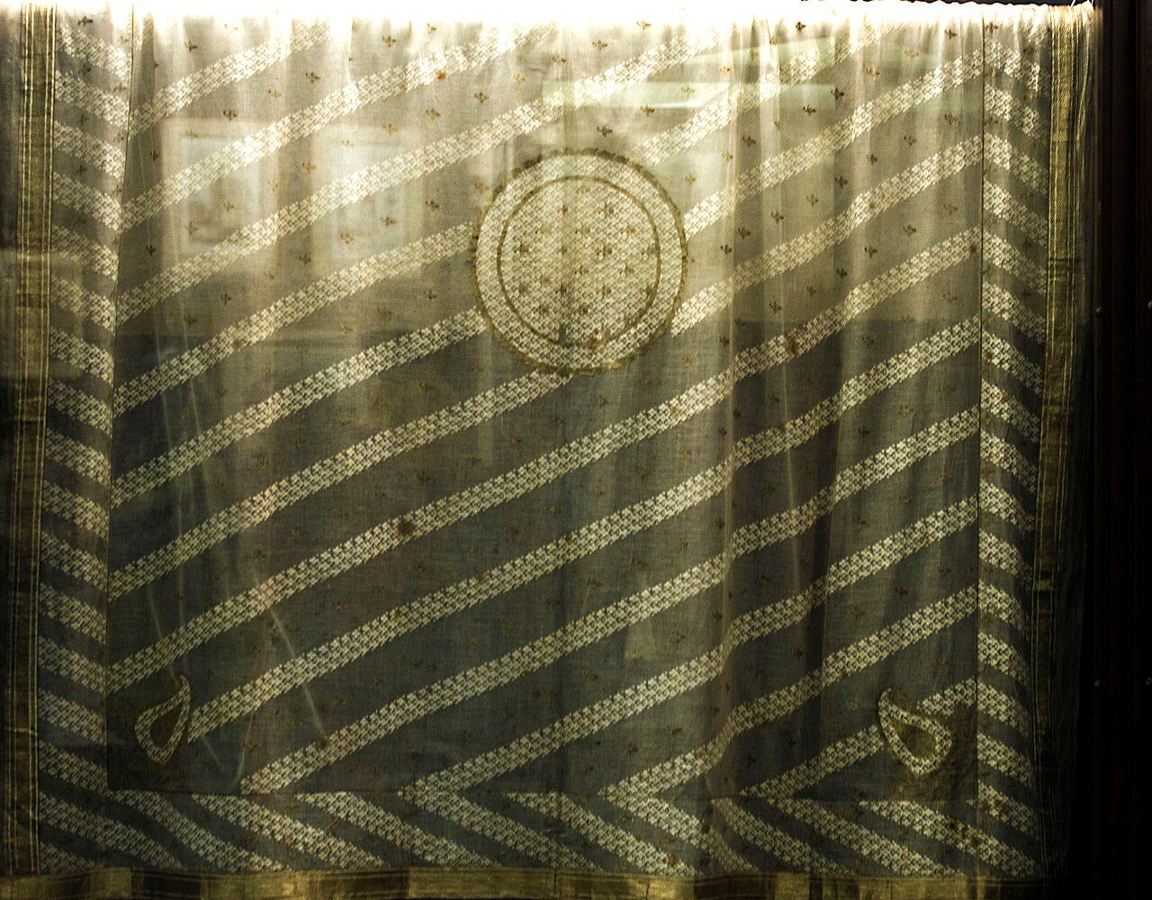 Muslin was once believed to have originated in Mosul, Iraq, but later its place of origin was transferred farther east particularly Dhaka, Bangladesh. Dhakai Jamdani muslins decorated with gorgeous patterns was one of the Mughal Empire's prestigious imports.