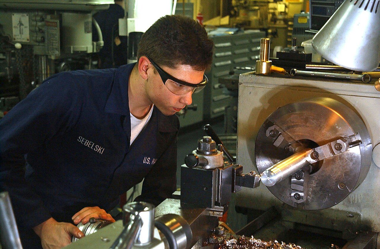 Original description: 040225-N-6125G-038 Atlantic Ocean (Feb. 25, 2004) – Fireman Justin Sebelski fabricates specialized parts on a lathe in the machine shop aboard USS Harry S. Truman (CVN 75). The nuclear powered aircraft carrier is currently undergoing carrier qualifications…