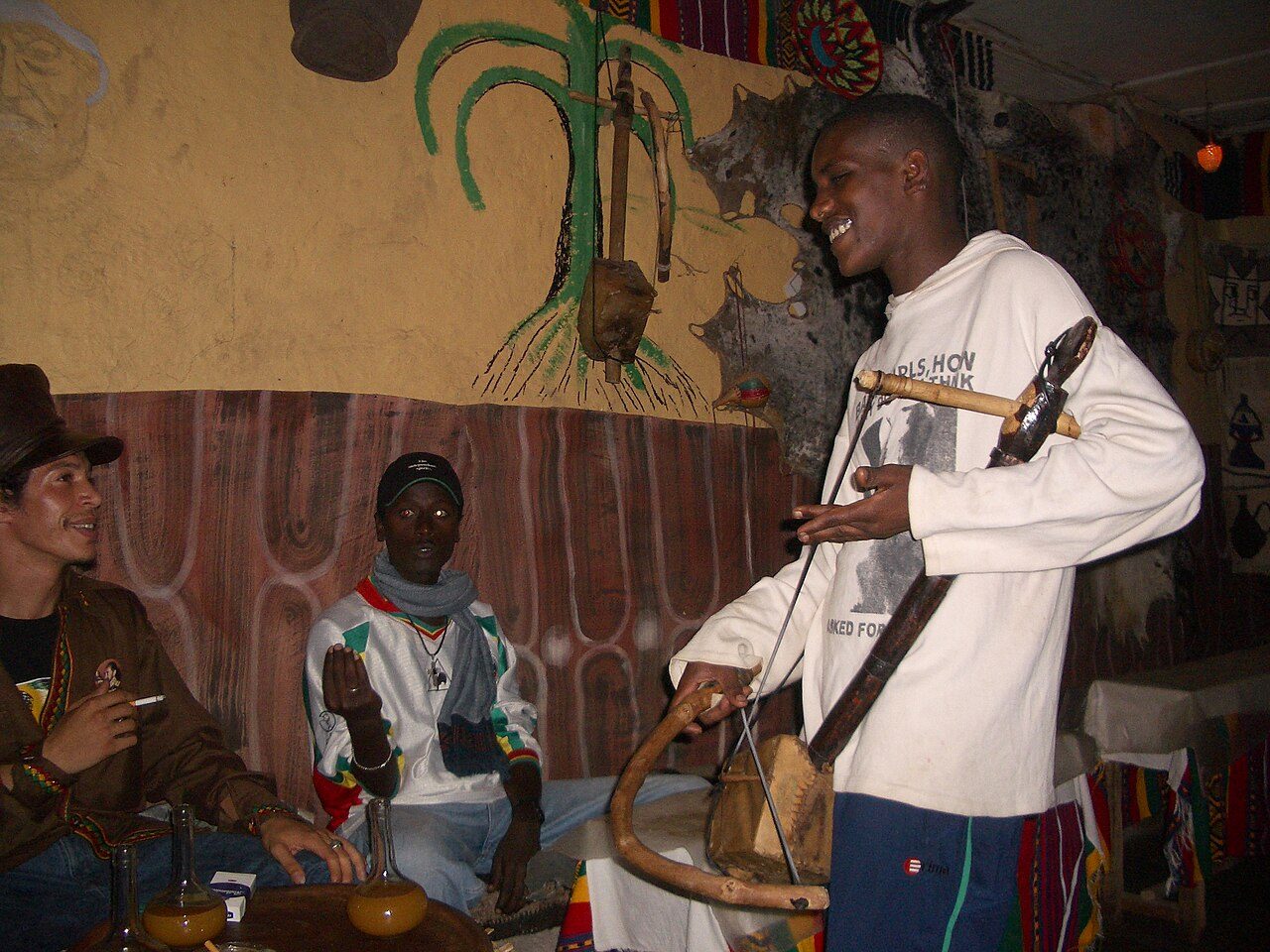 Original caption states "We hit the next town, and immediately went out to the local tej bet (honey wine bar) to hear an azmari (minstrel/one-man improv act. We didn't understand anything he said, but he was pretty cool anyway."