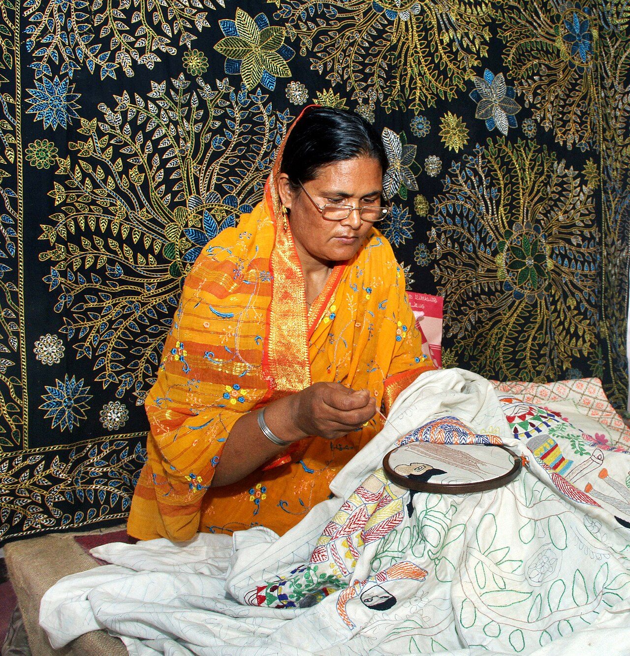 A village woman in Bangladesh stiching a Nakshi Kantha, 2015