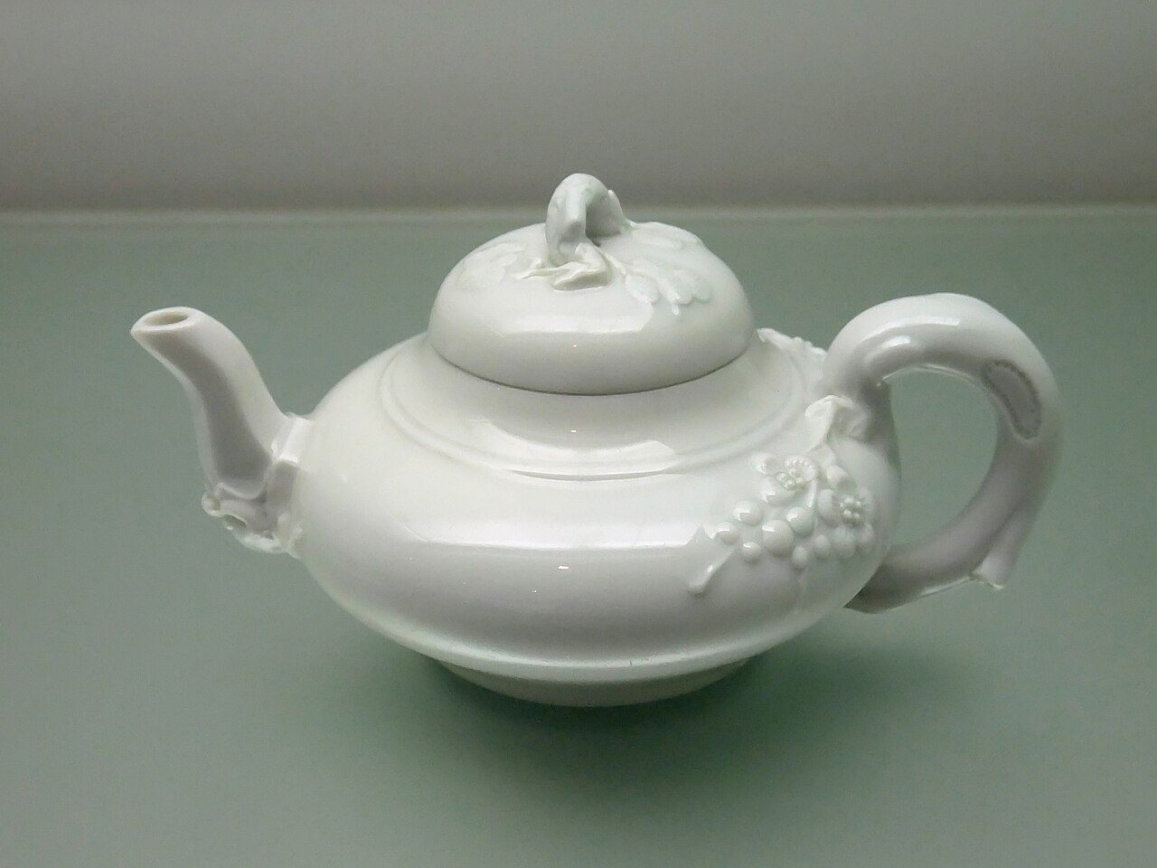 Teapot with plum blossom design in relief in white glaza, Dehua ware. An exhibit on display at the Hong Kong Museum of Art.