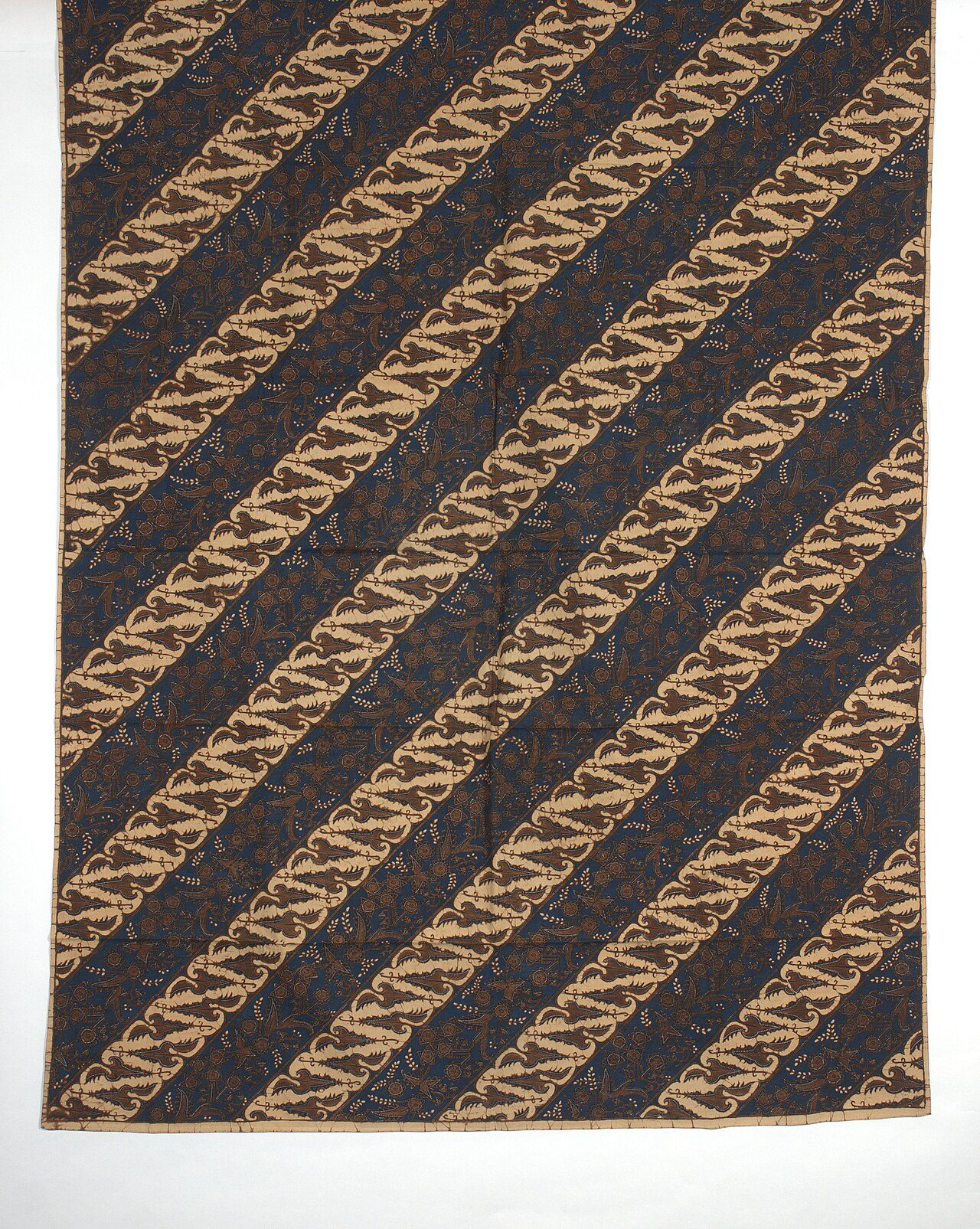 Wikkelrok 'Wikkelrok met parang patroon' Wikkelrok, kain panjang, met motieven geïnspireerd op parang motieven waarbinnen in bruin bloem- en bladmotieven. 1875-1900 Afmetingen: 105,5 × 274 cm (41,5 × 107,9 in.)