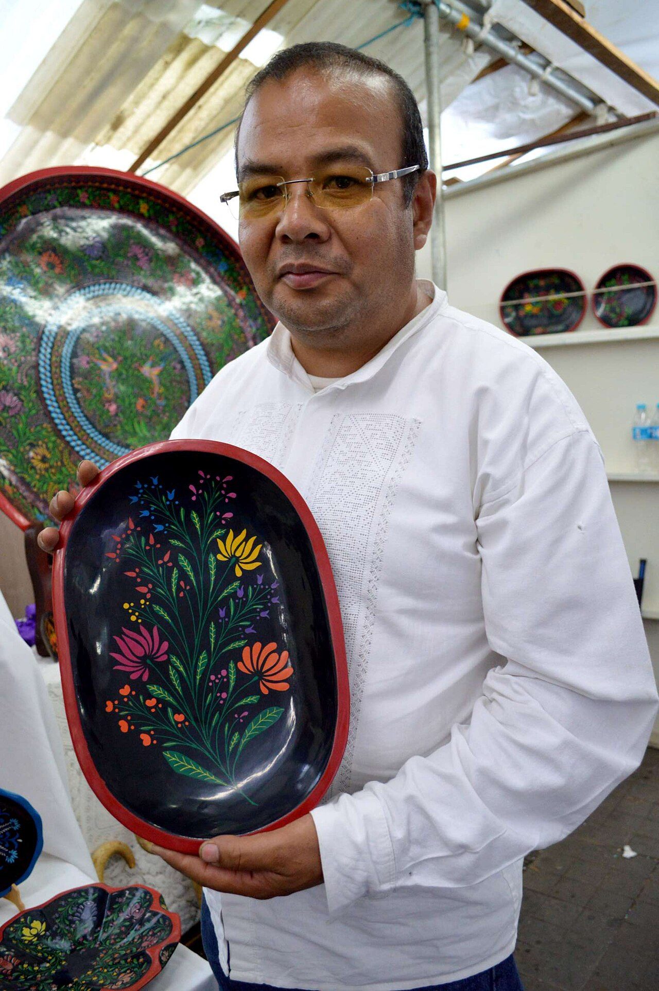 Artisan Juan Valencia Villalobos of Urupapan with maque piece at the Tianguis de Domingo de Ramos in Uruapan, Michoacan