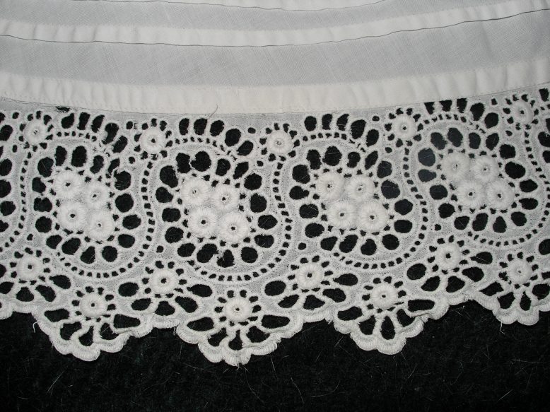 Handmade cotton cutwork frill on machine-sewn tucked petticoat.