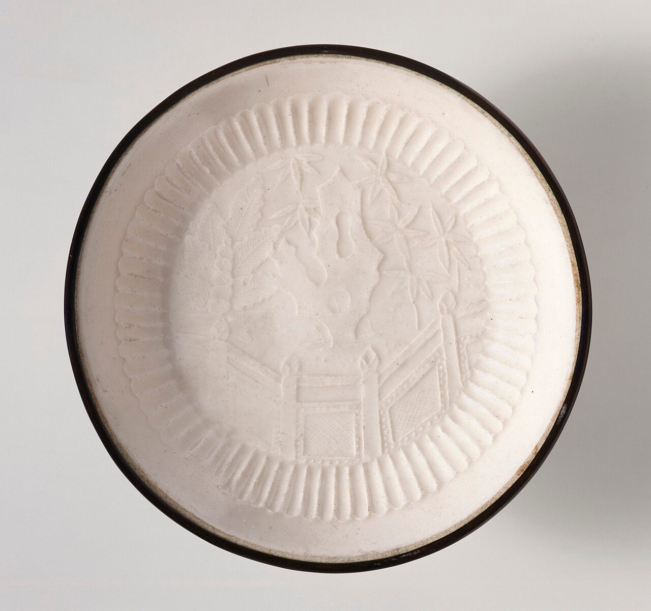 China, Hebei Province, Quyang County, late Jin dynasty or early Yuan dynasty, about 1200-1300 Furnishings; Serviceware Ding ware, molded stoneware with impressed decoration, transparent glaze, and banded metal rim Gift of Nasli M. Heeramaneck (M.73.48.106) Chinese Art