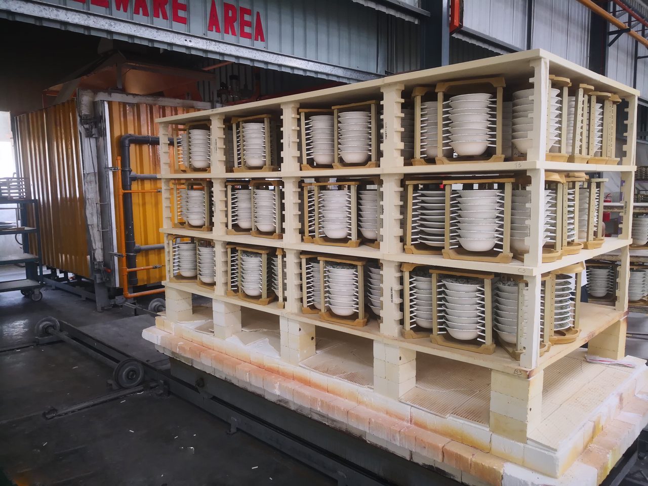 All of the dried glazed ware is being put on segger (firing rack); put on the car kiln before glost firing di kilang Claytan