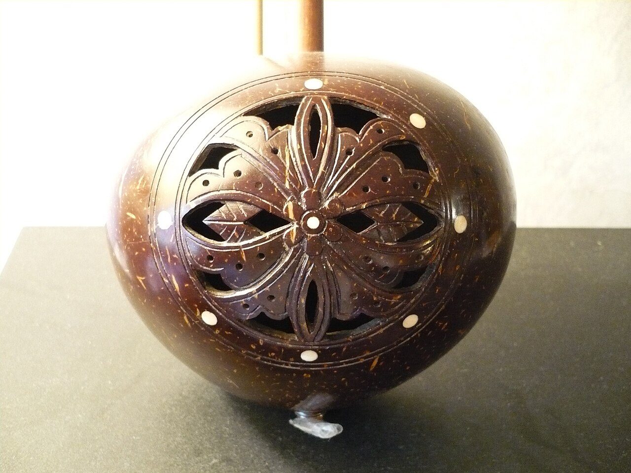 Detail of the carved back of the body of a Chinese yehu (2-stringed fiddle with coconut shell body). The white dots appear to be bone inlay. Photo taken in Kent, Ohio, United States. The yehu was probably made in Guangdong , China .