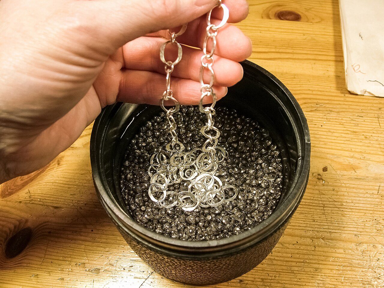 Making a silver chain. Placing the chain in a tumbler with water, polishing agent and mixed steel shots, pins, cones and ballcones. The tumbler is run about 18 hours. Photographed at Sophies Silver's workshop in Visby, Gotland, Sweden.