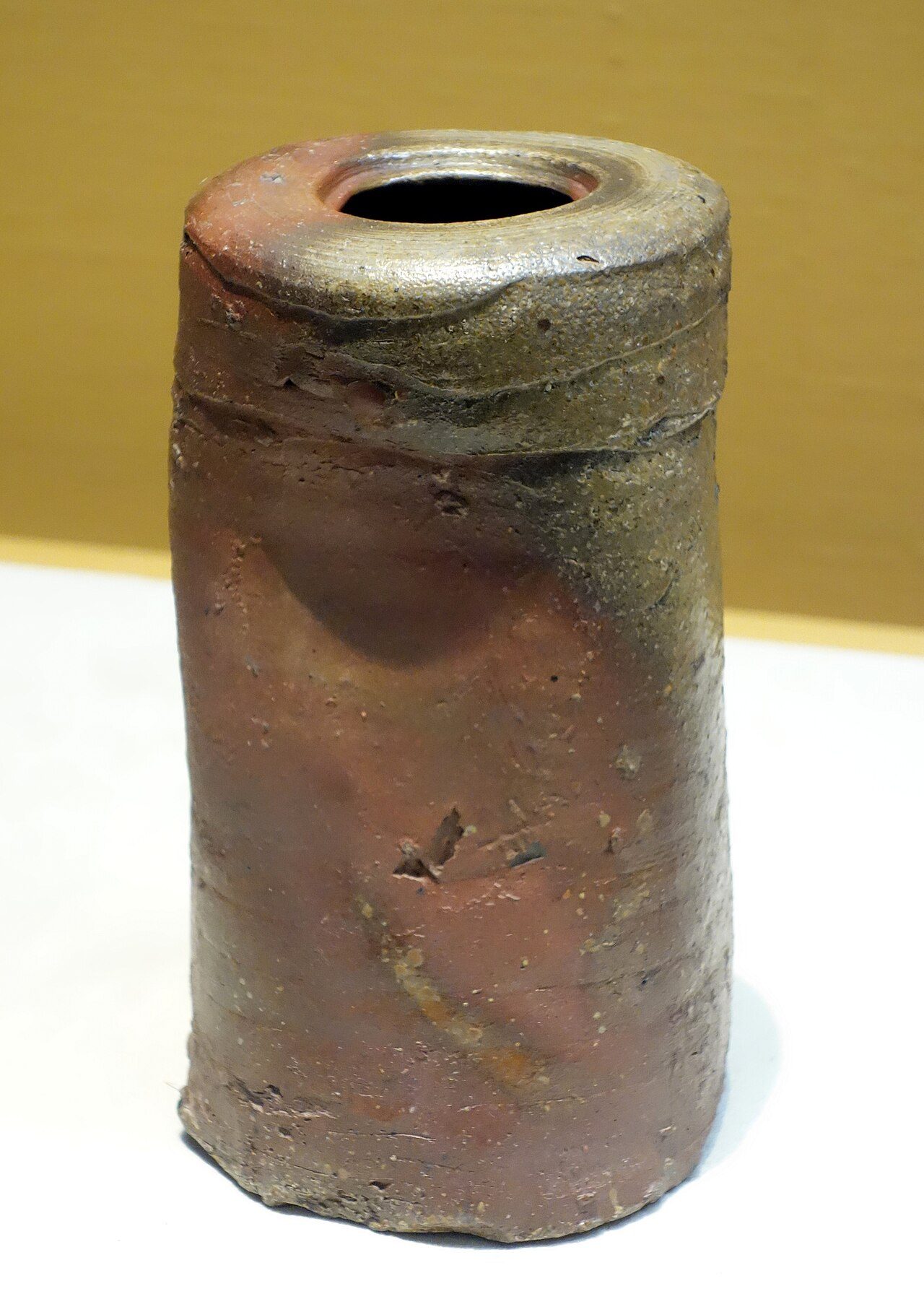 Flower vase in shape of travel pillow Artist: Bizen ware Period/Century: Edo period, 17th century Material: Stoneware with natural ash glaze Donor: Gift of Mr. Hirota Matsushige Collection reference no. G-5300 Exhibit in the Tokyo National Museum, Tokyo, Japan. This artwork is…