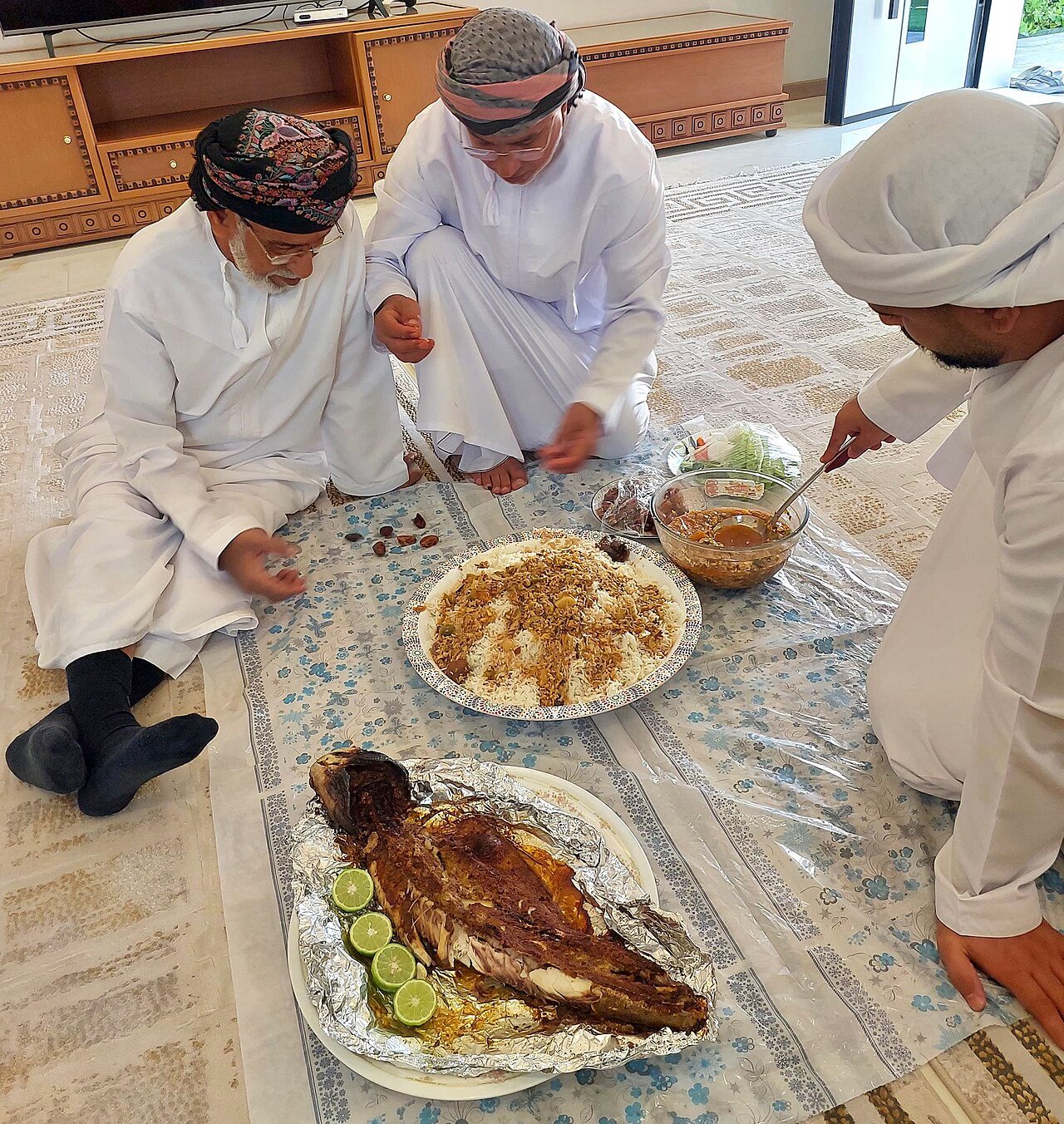 Omani men eating Maraq, also known as Saloona