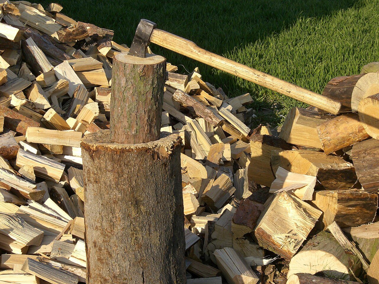 Axe with chopping stump and chopped and unchopped wood.