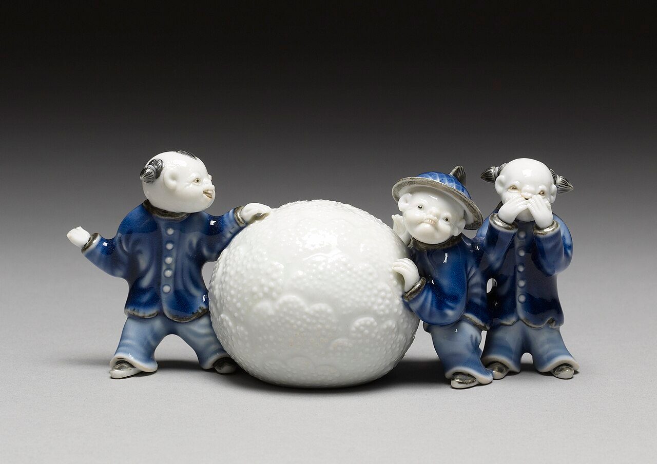This Hirado ware brush rest depicts three Chinese boys in the process of rolling a snowball.