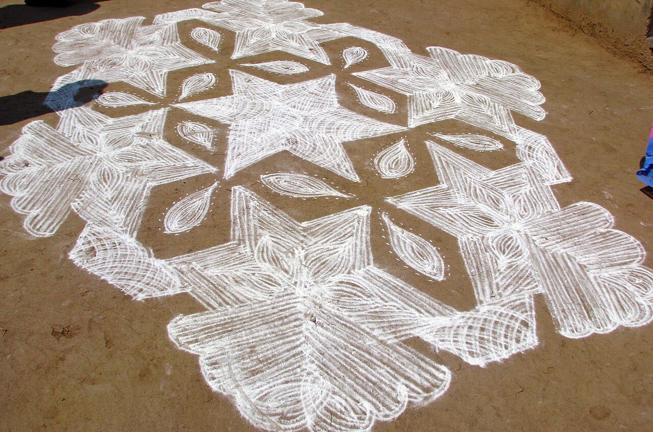 An intricate floor design done in chalk called "kolam" (similar to the pan-Indian artform of rangoli), intricate decorative designs are drawn by the women in chalk or rice flour front of their hut, house or apartment block every morning anew. The designs can be simple or very…