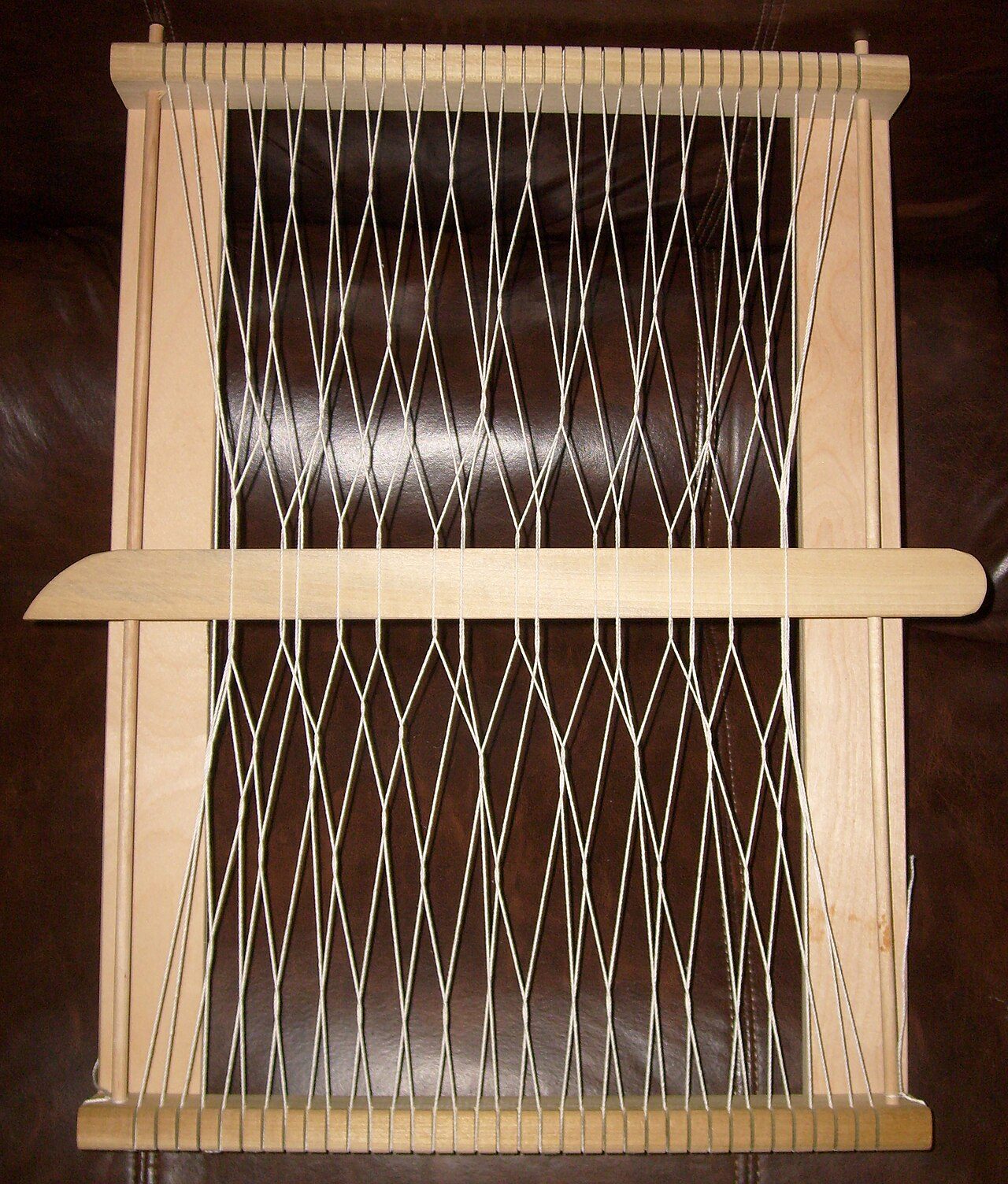 Demonstration example of sprang under construction on a lap loom.