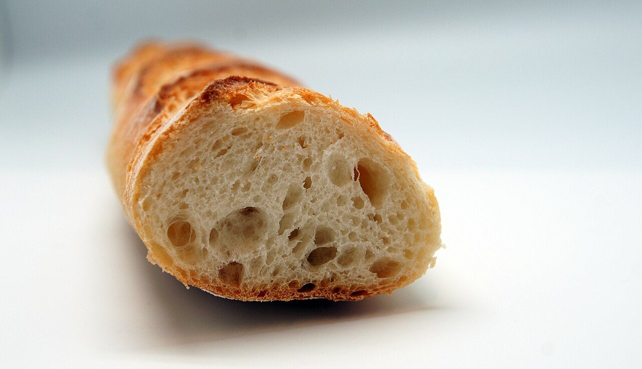 Closeup view of a cut baguette showing the inner structure.