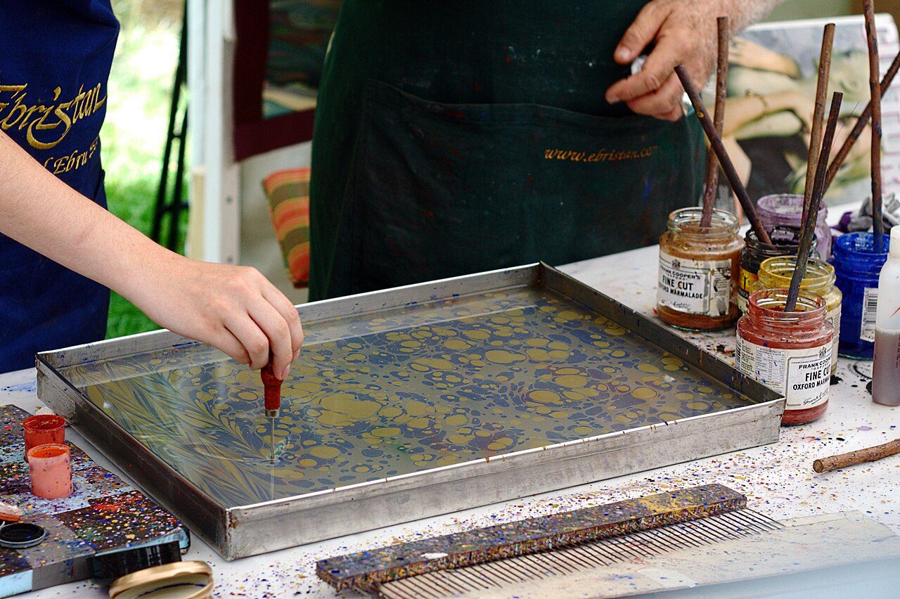 Oil-based inks in a tank of water being prepared for marbling.