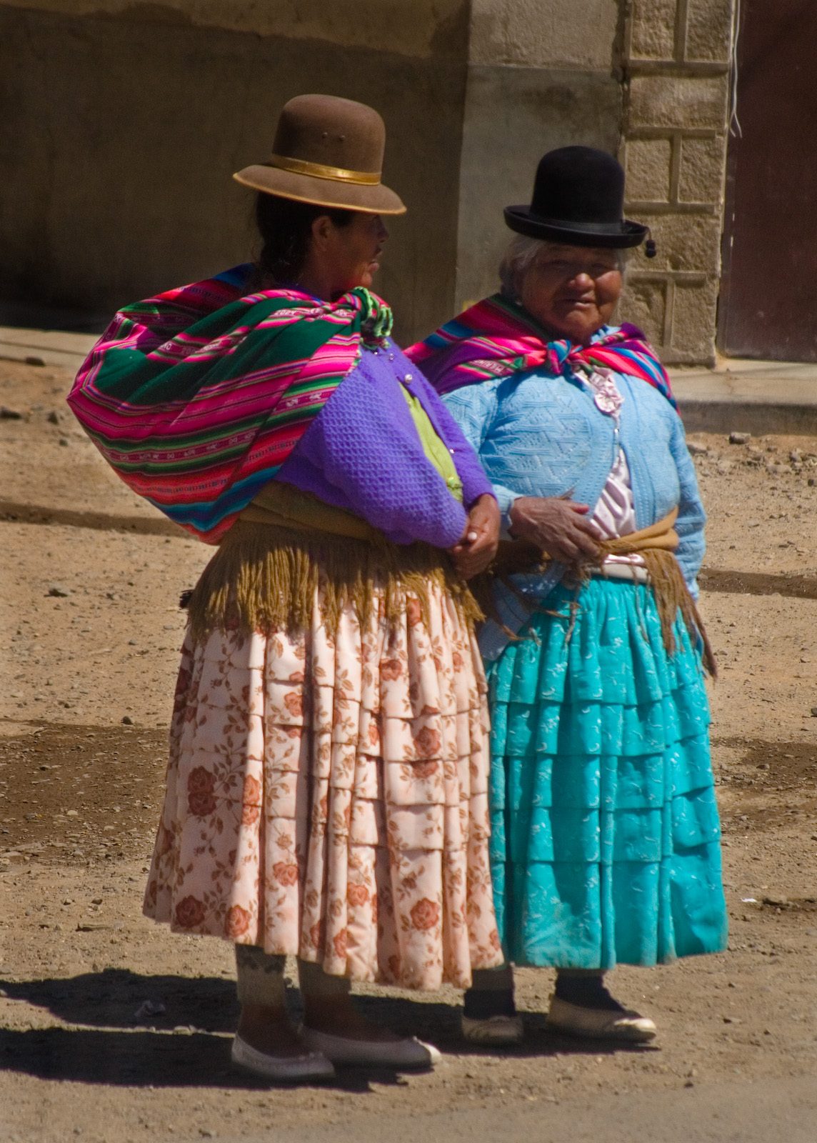 In Bolivia live both Aymara and Quecha people. The Aymara women wear skirts that are slightly lower in the front than in the back.