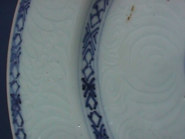 Plate, blue and white plate sparsely decorated with geometrical patterns in two circles and a flower surrounded by a double ring in the centre with incised patterns under the glaze. An hua (secret) decorated.
