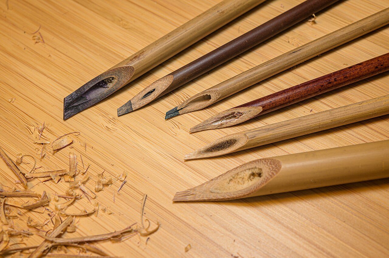 Different kinds of handmade wooden calligraphy pens made of different reeds and bamboos. The wooden shavings are the remains resulted from carving these pens. These traditional handmade pens are used for writing Arabic-based scripts such as Jawi, Persian, Urdu and more.
