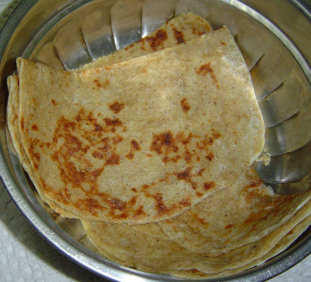 A type of bread (similar to Roti ) stuffed with grated coconut and Gur .