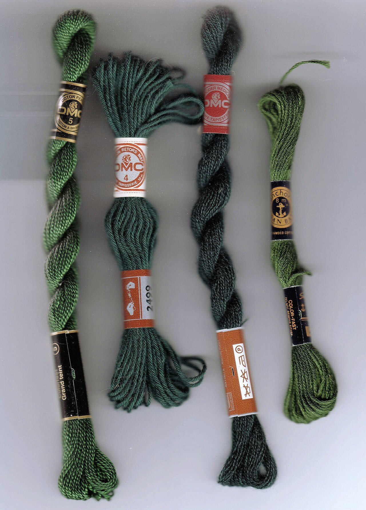 Embroidery thread, left to right: No. 5 perle cotton (coton perlé), matte cotton tapestry yarn, tapestry wool, cotton stranded embroidery floss.